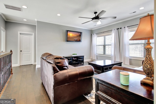 living area featuring dark wood-style flooring, visible vents, crown molding, and baseboards