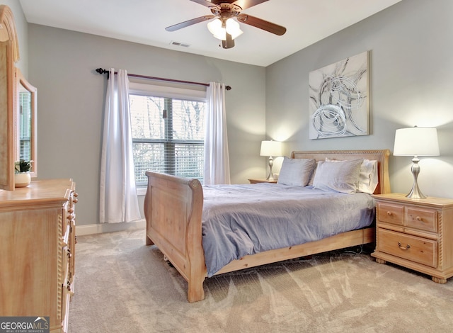 bedroom with light carpet, a ceiling fan, visible vents, and baseboards