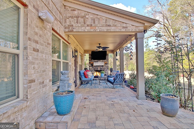 view of patio / terrace featuring a ceiling fan and a lit fireplace