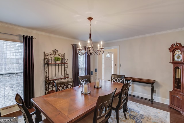 dining space featuring dark wood-style floors, ornamental molding, baseboards, and a notable chandelier