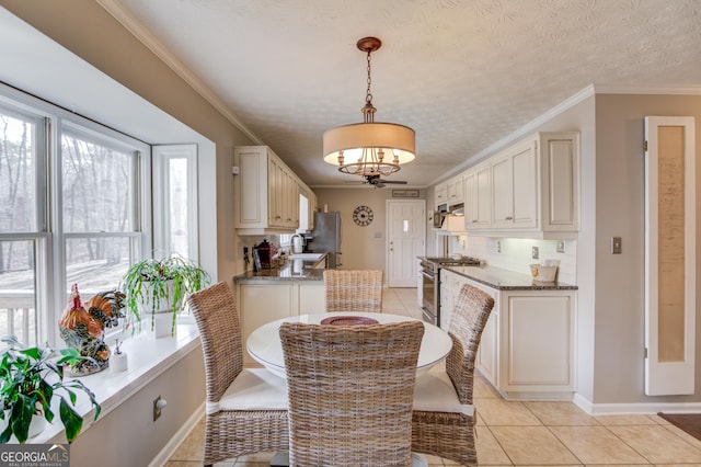 dining space with ornamental molding, light tile patterned flooring, a textured ceiling, and baseboards