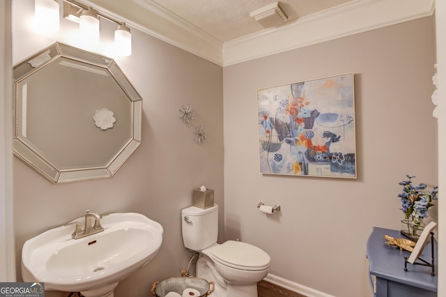 bathroom with visible vents, toilet, ornamental molding, a sink, and baseboards