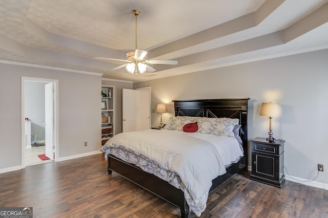 bedroom with baseboards, a tray ceiling, and wood finished floors