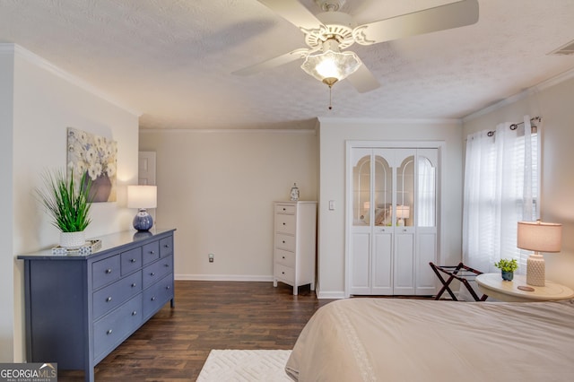 bedroom featuring a textured ceiling, ornamental molding, dark wood-style flooring, and baseboards