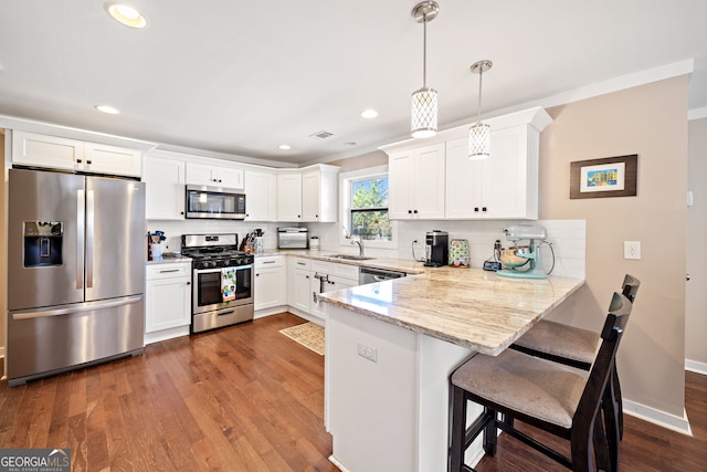 kitchen featuring appliances with stainless steel finishes, dark wood-style flooring, a peninsula, and decorative backsplash