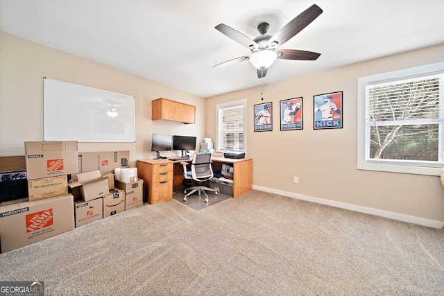 carpeted home office featuring ceiling fan and baseboards