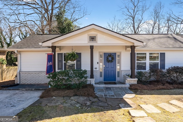 view of front facade featuring a shingled roof and brick siding