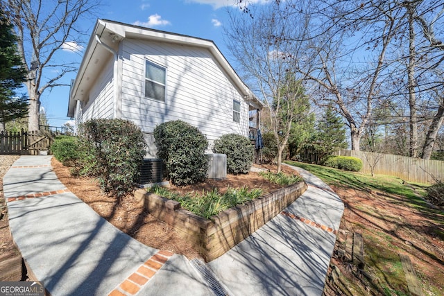 view of side of property with fence and central AC unit