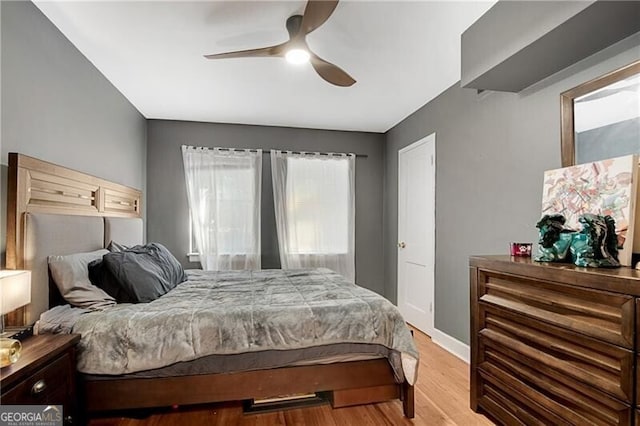 bedroom featuring light wood-style flooring, baseboards, and a ceiling fan