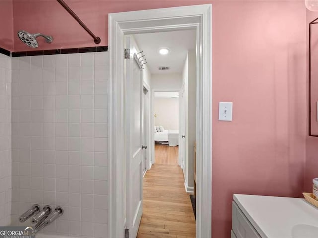 full bath with  shower combination, visible vents, wood finished floors, and vanity