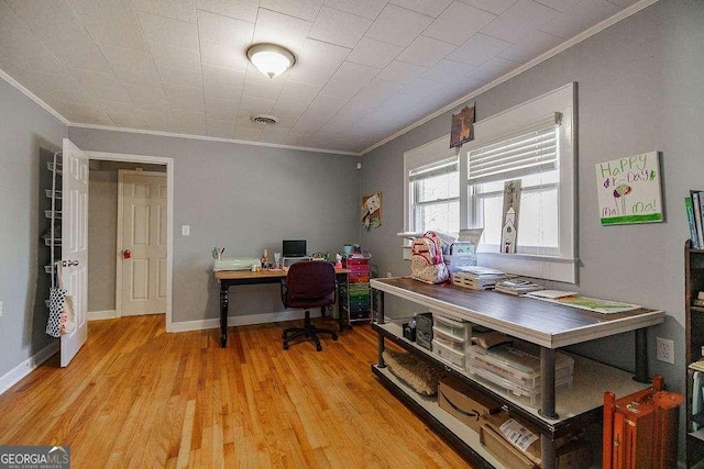 office space featuring visible vents, baseboards, light wood-style flooring, and crown molding