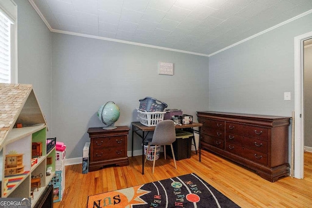 office featuring baseboards, light wood-type flooring, and crown molding