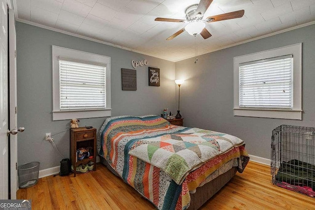 bedroom featuring ornamental molding, wood finished floors, a ceiling fan, and baseboards