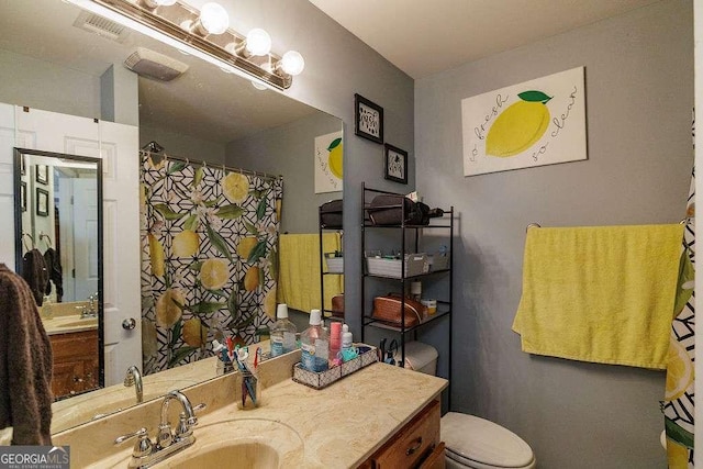 bathroom with visible vents, vanity, and toilet