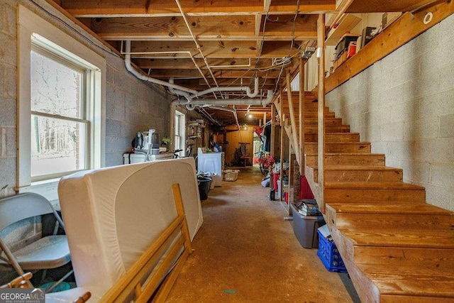 below grade area with stairs, washer / clothes dryer, and concrete block wall