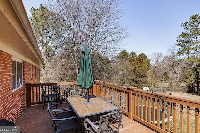 wooden terrace with outdoor dining space and fence