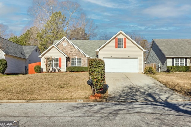 traditional-style house featuring driveway, a garage, stone siding, fence, and a front lawn