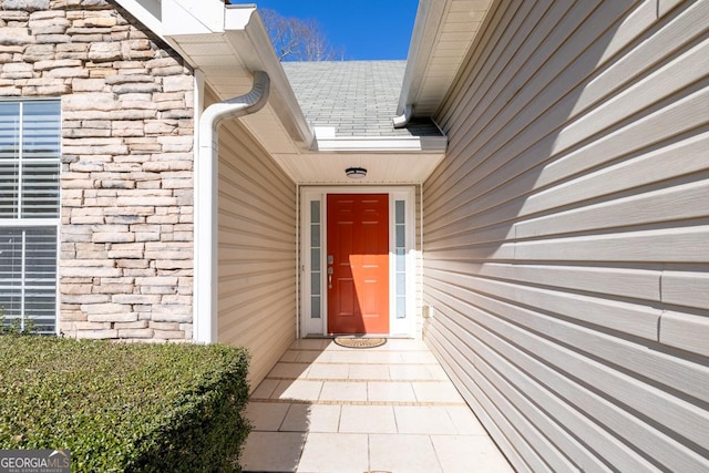 property entrance featuring a shingled roof