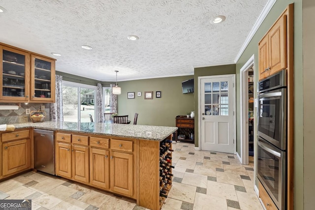 kitchen featuring glass insert cabinets, brown cabinetry, hanging light fixtures, and a peninsula