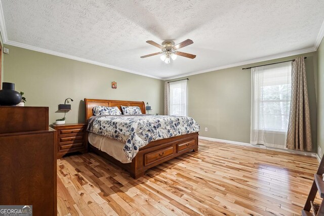 bedroom featuring light wood finished floors, baseboards, ornamental molding, and a textured ceiling