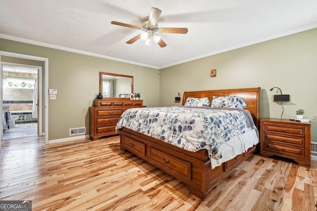 bedroom featuring light wood finished floors, baseboards, visible vents, and ornamental molding