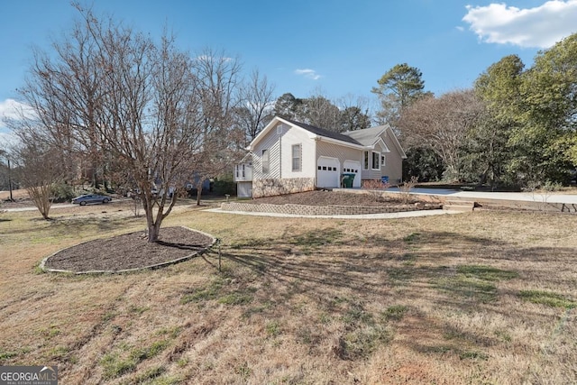 view of side of home featuring a yard and an attached garage