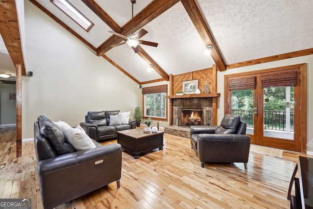 living area with a healthy amount of sunlight, hardwood / wood-style floors, and beamed ceiling