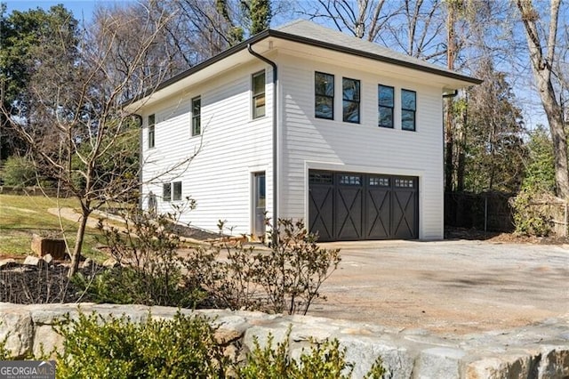 view of property exterior featuring a garage and driveway