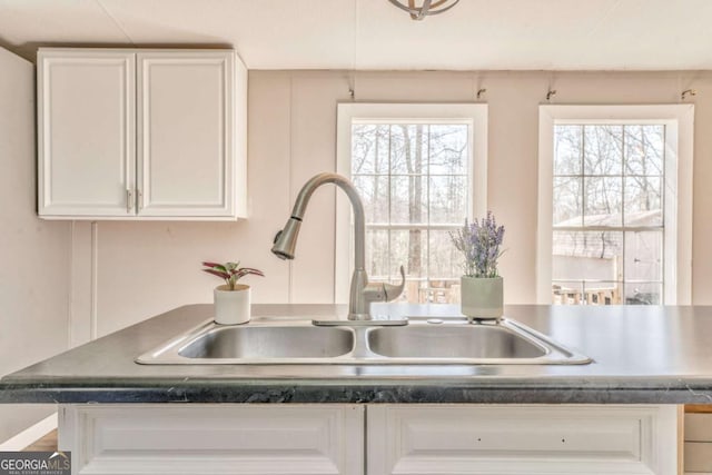 room details with white cabinetry and a sink