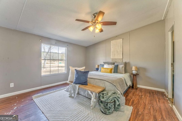 bedroom featuring lofted ceiling, baseboards, and dark wood-type flooring