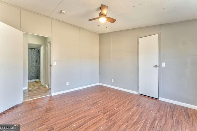 unfurnished room featuring ceiling fan, baseboards, and wood finished floors