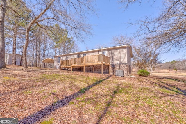 rear view of house featuring cooling unit and a wooden deck