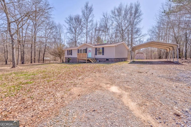 view of front of house featuring driveway, crawl space, and a detached carport