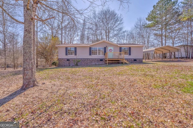 manufactured / mobile home featuring crawl space, a wooden deck, a front lawn, and a detached carport