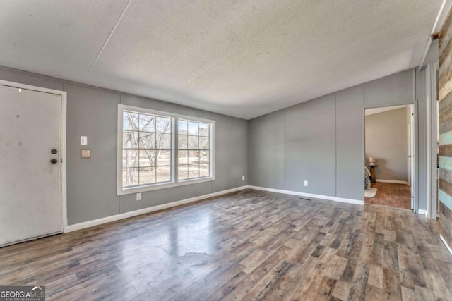 entrance foyer featuring a textured ceiling, baseboards, and wood finished floors