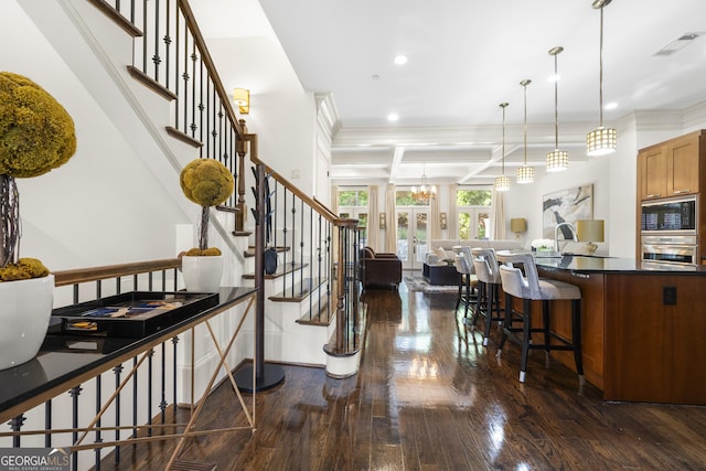 kitchen with dark countertops, open floor plan, visible vents, and dark wood finished floors