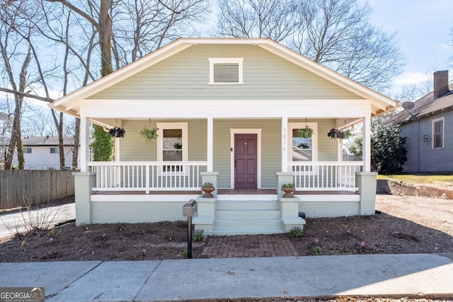 bungalow with covered porch and fence