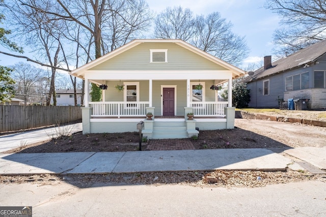 bungalow-style house with a porch and fence