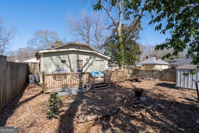 rear view of house featuring a shed, a fenced backyard, an outdoor structure, and cooling unit