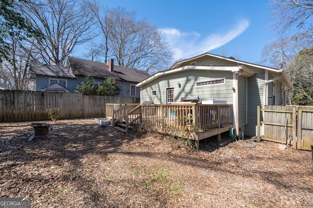 back of house featuring a deck and fence