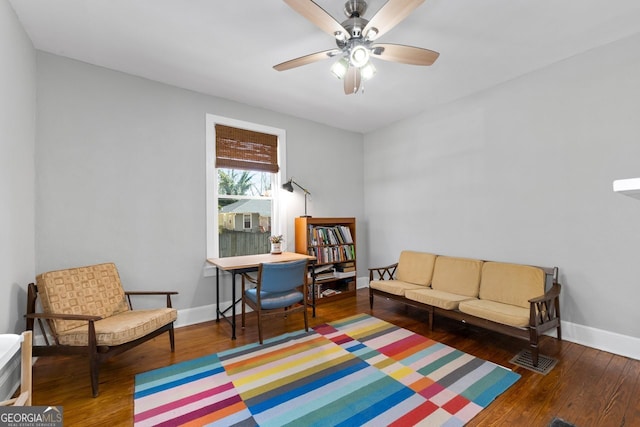 sitting room with a ceiling fan, baseboards, and wood finished floors