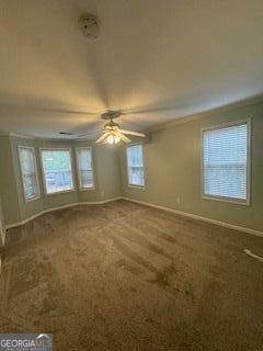 interior space featuring crown molding, a ceiling fan, and baseboards