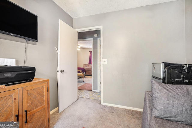 office area featuring a textured ceiling, carpet floors, and baseboards