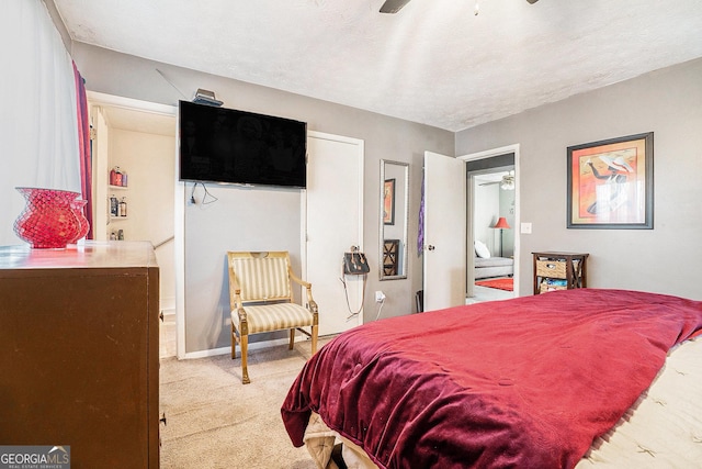 bedroom with a textured ceiling, carpet floors, ceiling fan, and baseboards