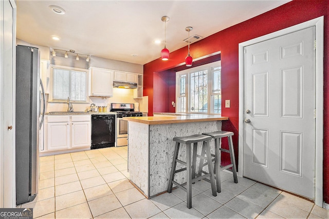 kitchen with under cabinet range hood, white cabinetry, visible vents, and stainless steel appliances