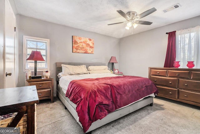 bedroom with visible vents, light carpet, and multiple windows