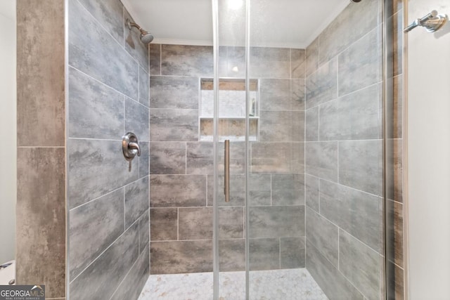 full bathroom with a shower stall and crown molding