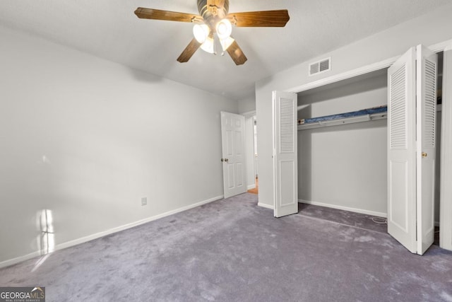 unfurnished bedroom with baseboards, visible vents, ceiling fan, dark carpet, and a closet