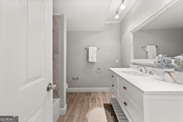 full bath with baseboards, toilet, rail lighting, vanity, and wood finish floors