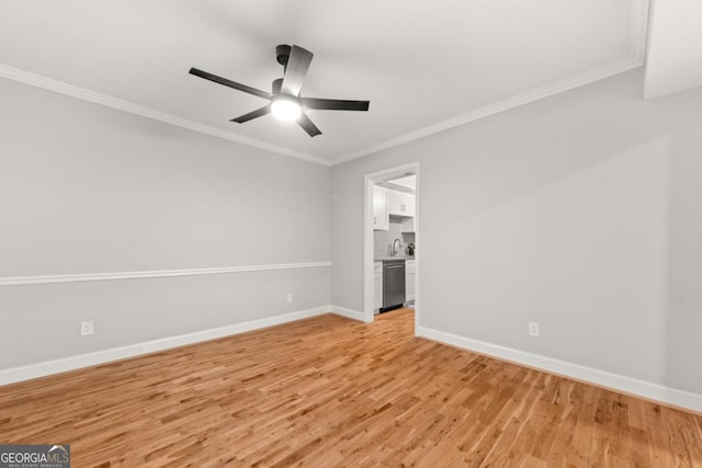 spare room with light wood finished floors, ceiling fan, baseboards, and crown molding